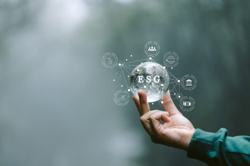 ESG icon in hand for environmental, social and governance in sustainable and ethical business on the Network connection on a green background. World sustainable environment concept.